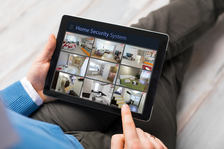 Man looking at home security system on his tablet