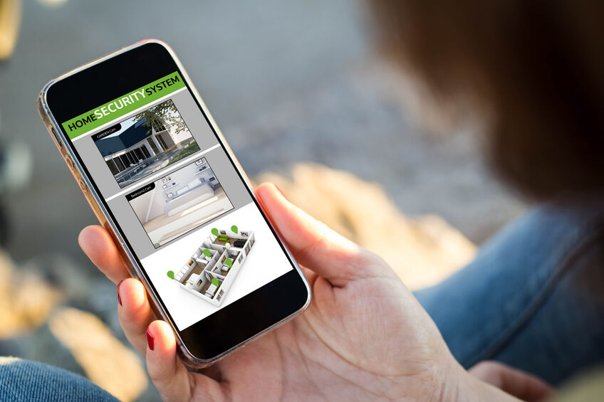 Woman looking at live feed on her phone of her home security system