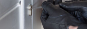 Thief with a bar of iron in the hand to open a door